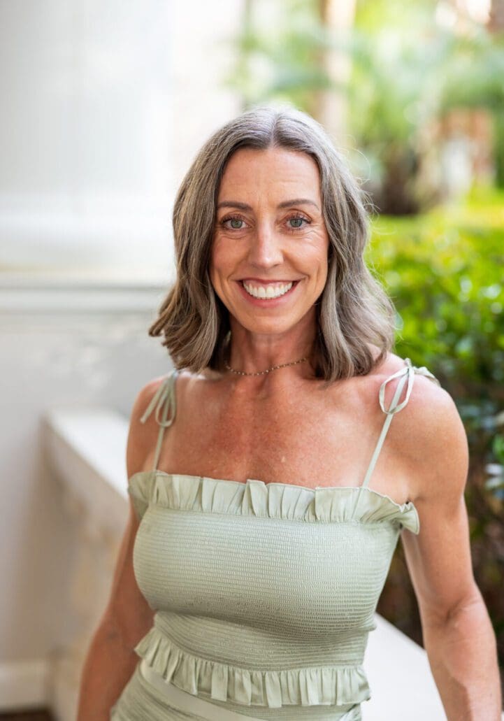 Smiling woman in a light green outfit.