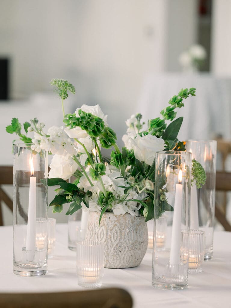 Floral centerpiece with candles on table